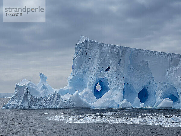 Ein großer Eisberg mit Löchern und Bögen bildete sich in der Nähe von Coronation Island  den Süd-Orkneys  der Antarktis und den Polarregionen