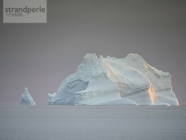 Sonnenuntergang auf einem großen Eisberg auf See in Richtung Peter-I-Insel  Bellingshausensee  Antarktis  Polarregionen