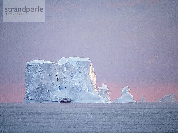 Sonnenuntergang auf einem großen Eisberg auf See in Richtung Peter-I-Insel  Bellingshausensee  Antarktis  Polarregionen