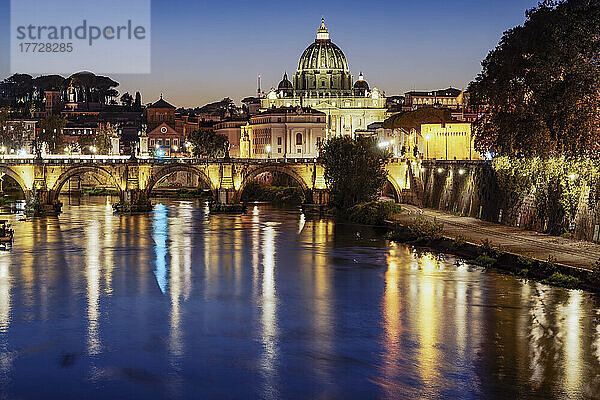 Nachtansicht der San-Angelo-Brücke am Tiber mit Hintergrund des beleuchteten Petersdoms im Vatikan  Rom  Latium  Italien  Europa