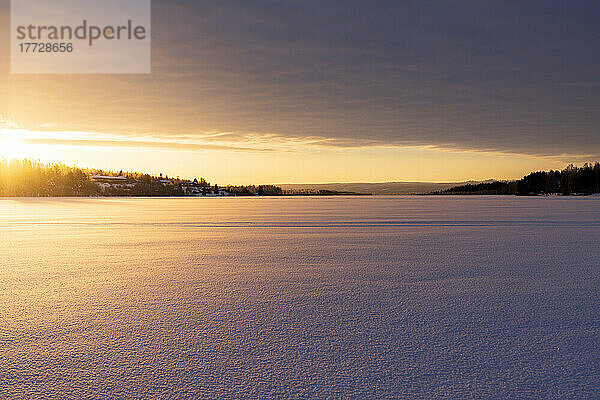 Arktischer Sonnenaufgang über der gefrorenen  schneebedeckten Landschaft im Winter  Harads  Lappland  Schweden  Skandinavien  Europa