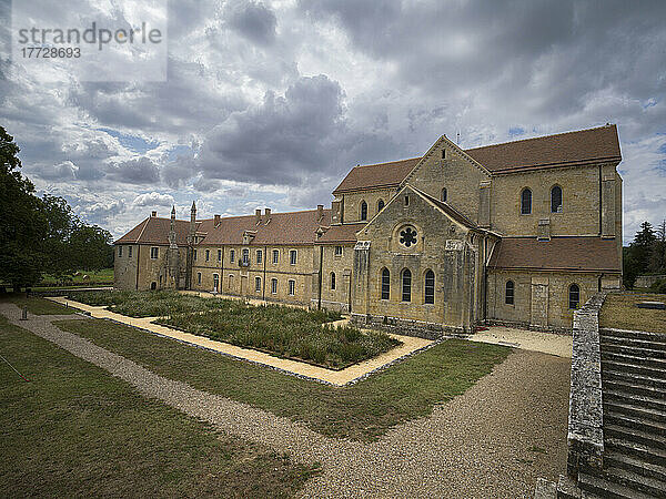 Garten und das Äußere der alten Abtei Noirlac an einem bewölkten Tag  Cher  Centre-Val de Loire  Frankreich  Europa
