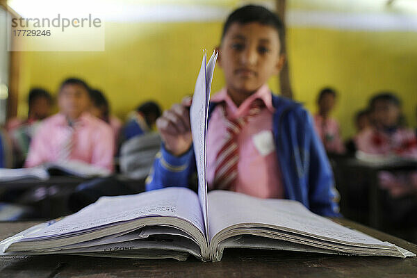 Grundschule  Junge mit Buch  Bildungskonzept und Schulleben  Lapilang  Dolakha  Nepal  Asien