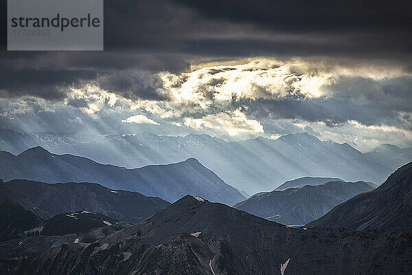 Sonnenstrahlen filtern zwischen schwarzen Wolken bei Sonnenuntergang  Stilfserjoch-Gebirgspass  Stilfserjoch-Nationalpark  Veltlin  Lombardei  Italien  Europa