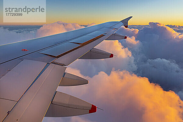 Flugzeugflügel bei Sonnenuntergang über Wolken  Italien  Europa