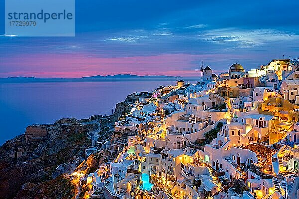 Berühmte griechische ikonischen Selfie Spot Touristenziel Oia Dorf mit traditionellen weißen Häusern und Windmühlen in Santorini Insel in den Abend blaue Stunde  Griechenland  Europa