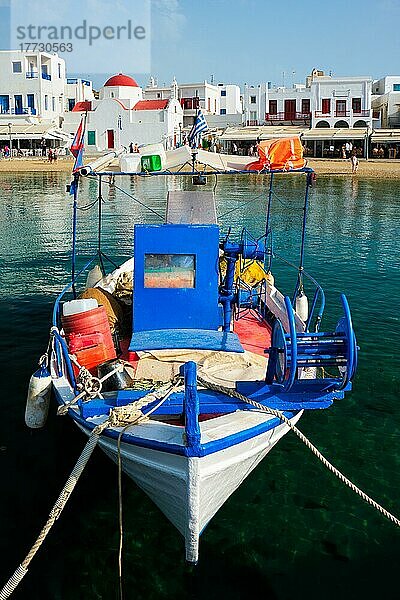 Blaues Fischerboot im Hafen der Stadt Chora auf der Insel Mykonos mit orthodoxer Kirche im Hintergrund  Griechenland  Europa