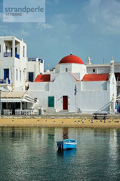 Blaues Fischerboot im Hafen der Stadt Chora auf der Insel Mykonos mit orthodoxer Kirche im Hintergrund  Griechenland  Europa