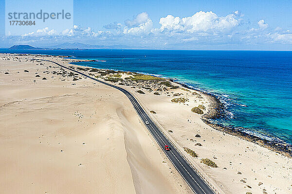 Autos unterwegs auf der Straße zwischen Sanddünen und Meer  Luftaufnahme  Naturpark Corralejo  Fuerteventura  Kanarische Inseln  Spanien  Atlantik  Europa