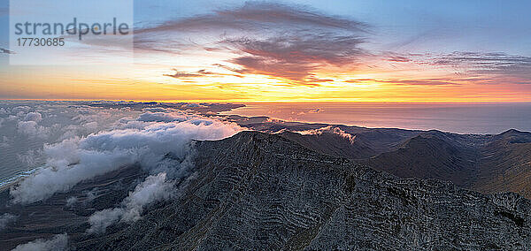 Brennender Himmel im Morgengrauen über dem Berggipfel Pico de la Zarza in einem Wolkenmeer  Jandia  Fuerteventura  Kanarische Inseln  Spanien  Atlantik  Europa