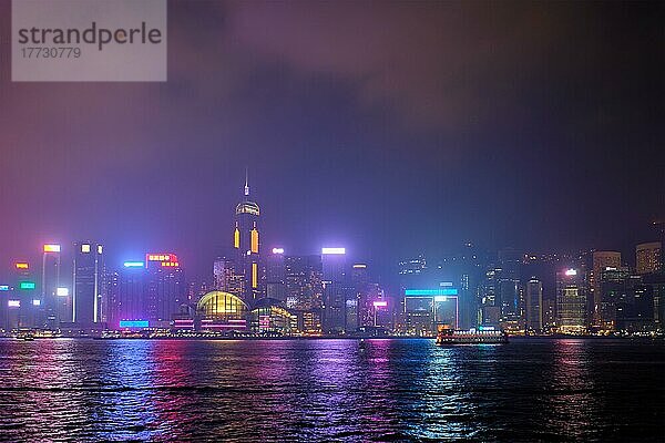 Hongkong Skyline Stadtbild Downtown Wolkenkratzer über Victoria Harbour in den Abend mit Lasern beleuchtet mit touristischen Boot Fähren  Hongkong  China  Asien