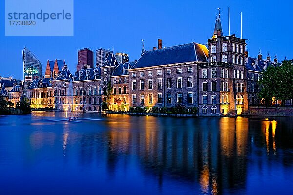 Blick auf das Parlamentsgebäude Binnenhof und den Hofvijver-See mit den abendlich beleuchteten Wolkenkratzern der Innenstadt im Hintergrund. Den Haag  Niederlande  Europa