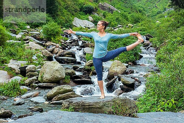 Yoga im Freien  Frau  die Ashtanga Vinyasa Yoga Balance Asana Utthita Hasta Padangushthasana  Extended Hand-To-Big-Toe Pose Position Haltung im Freien am Wasserfall