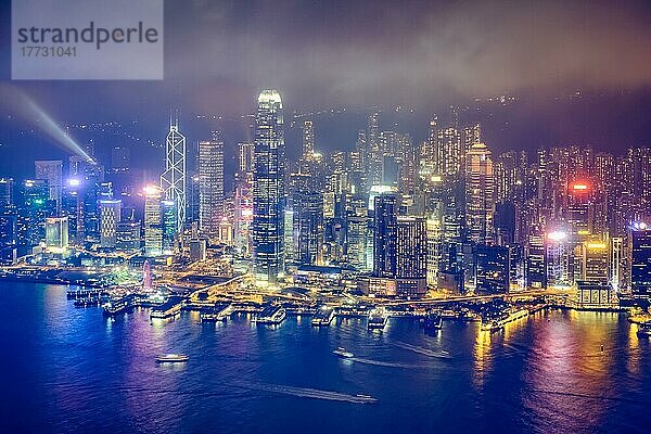 Luftaufnahme der beleuchteten Skyline von Hongkong mit den Wolkenkratzern der Innenstadt über dem Victoria Harbour in den Abendstunden. Hongkong  China  Asien