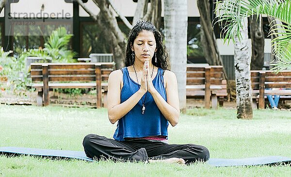 Ein Mädchen sitzt und macht Meditation Yoga im Freien  Frau macht Yoga im Freien  eine junge Frau macht Yoga mit geschlossenen Augen