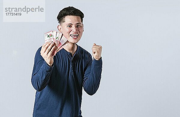 Aufgeregter Mann mit Geld in der Hand  erstaunter Mann mit Geldscheinen in der Hand  Konzept eines Mannes  der Geld verdient