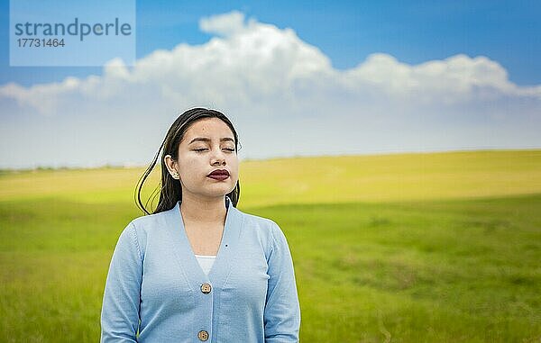 Ein junges Mädchen atmet frische Luft auf dem Feld  Junge Frau atmet frische Luft auf dem Feld am Morgen  Eine junge Frau atmet tief auf dem Feld