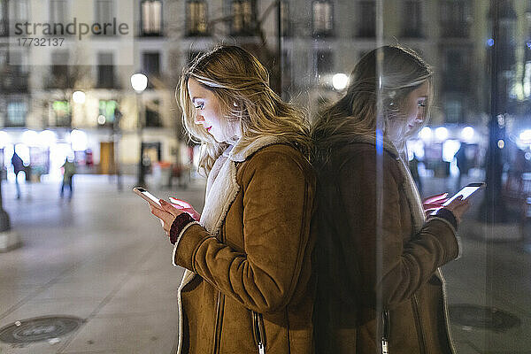 Junge Frau benutzt Smartphone in der Stadt