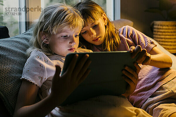Schwestern schauen sich zu Hause einen Tablet-PC an
