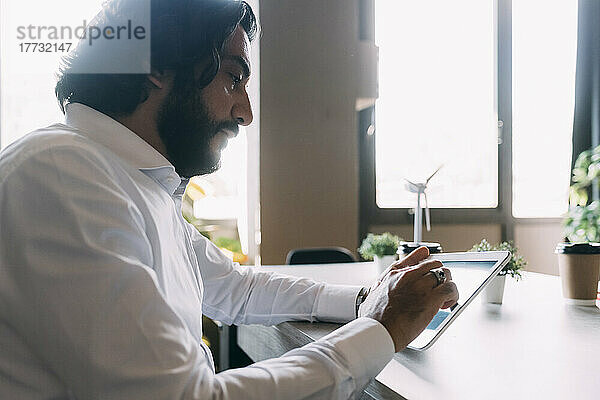 Reifer Geschäftsmann nutzt Tablet-PC im Büro
