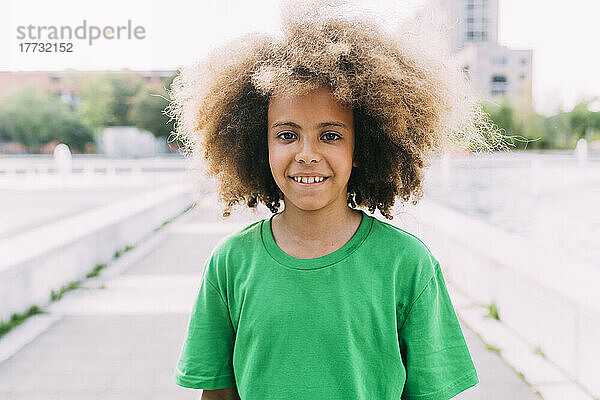 Smiling boy with Afro hairstyle wearing green t-shirt