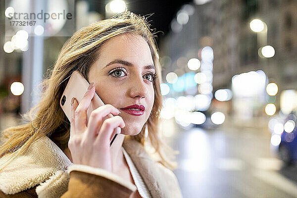 Junge Frau telefoniert in der Stadt mit dem Smartphone