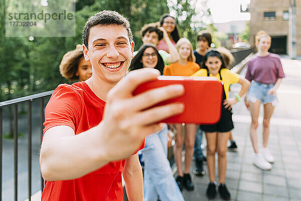 Glücklicher Teenager  der mit Freunden ein Selfie per Handy macht