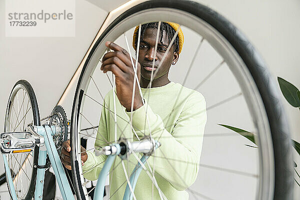 Junger Mann stellt zu Hause das Fahrradrad ein