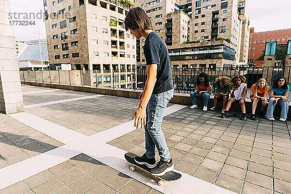 Boy skateboarding park lot on sunny day