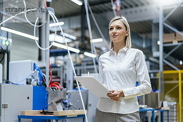 Geschäftsfrau hält digitales Tablet in der Fabrik