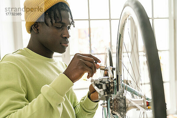 Junger Mann repariert zu Hause Fahrradkette