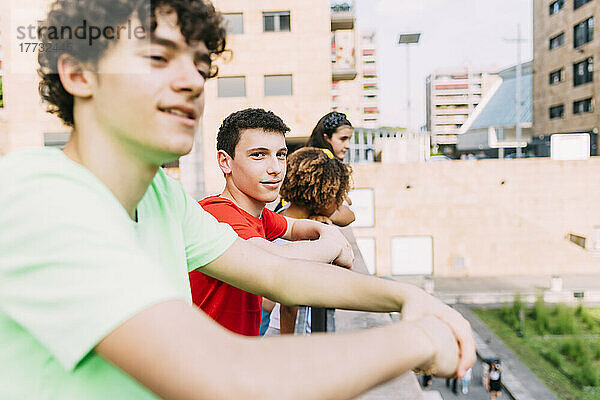 Lächelnder Teenager steht mit Freunden vor dem Gebäude