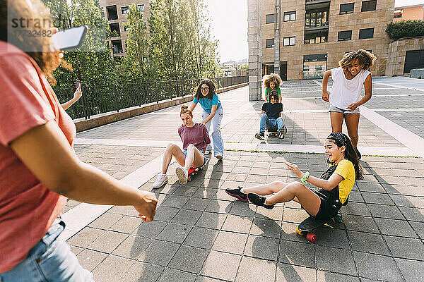 Multiracial friends skateboarding and having fun at parking lot