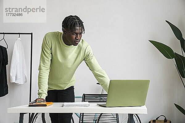 Geschäftsmann benutzt Laptop am Schreibtisch im Heimbüro