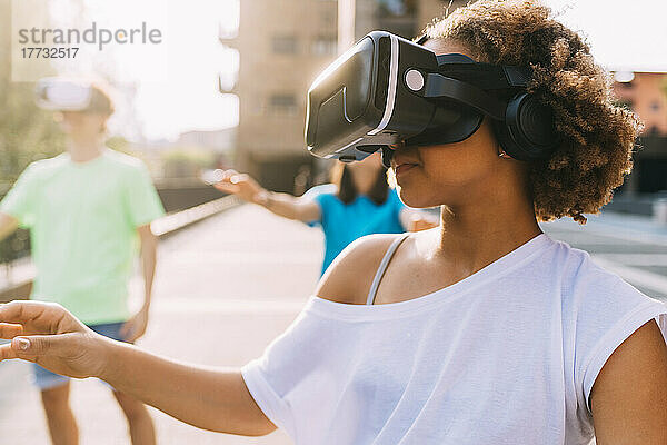 Mädchen trägt an einem sonnigen Tag einen Virtual-Reality-Simulator