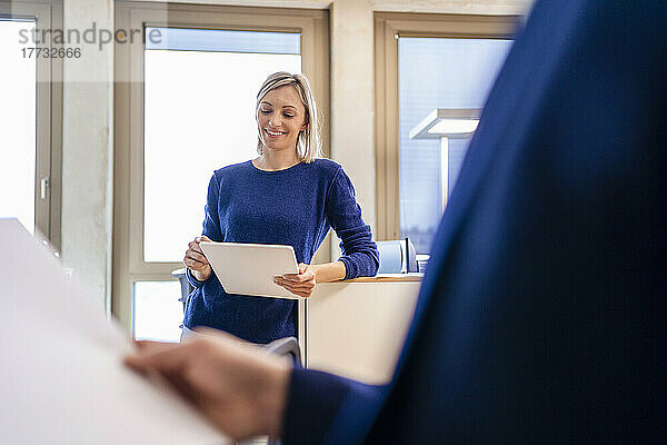 Lächelnde Geschäftsfrau nutzt digitales Tablet im Büro