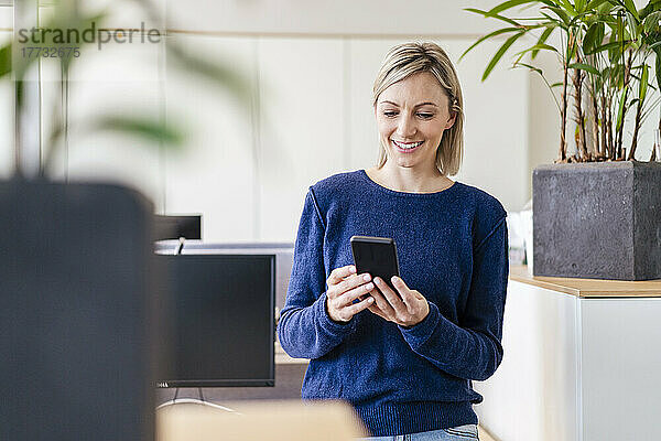 Geschäftsfrau nutzt Smartphone im Büro