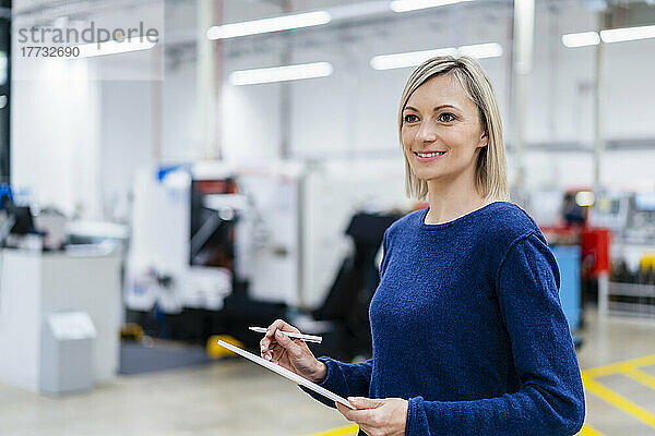 Geschäftsfrau hält digitales Tablet in der Fabrik