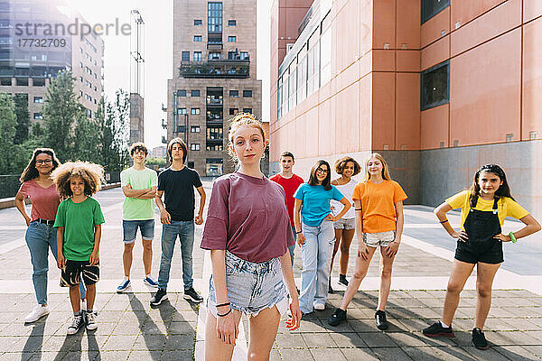 Smiling teenage girl standing in front of friends