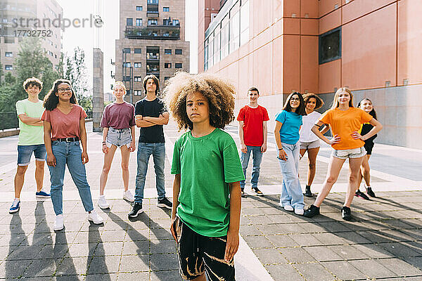 Junge mit Afro-Frisur steht vor Freunden