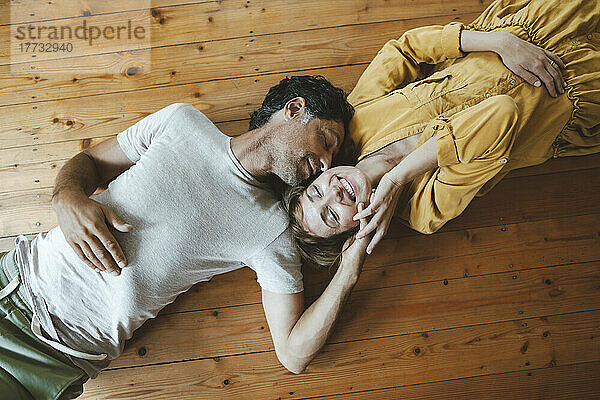 Reifer Mann und Frau liegen mit geschlossenen Augen zu Hause auf dem Boden