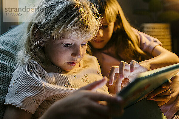 Schwestern nutzen gemeinsam Tablet-PC zu Hause