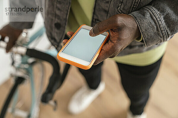 Mann mit Fahrrad nutzt Smartphone