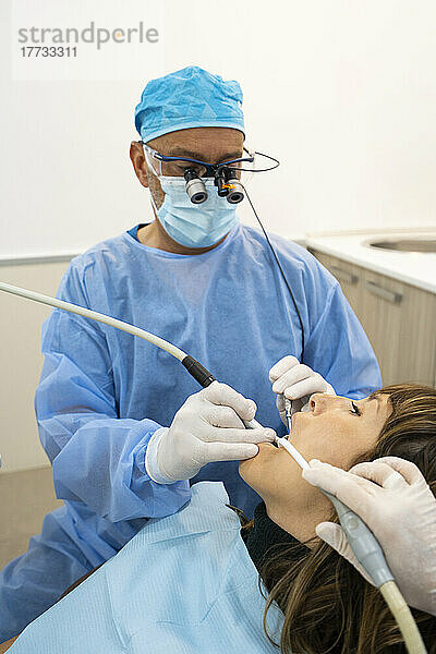 Dentists analyzing patient at clinic
