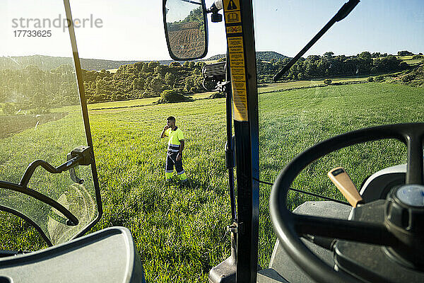 Junger Bauer steht an einem sonnigen Tag auf dem Feld