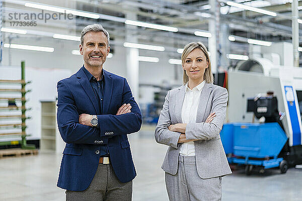 Porträt eines selbstbewussten Geschäftsmannes und einer Geschäftsfrau in der Fabrik