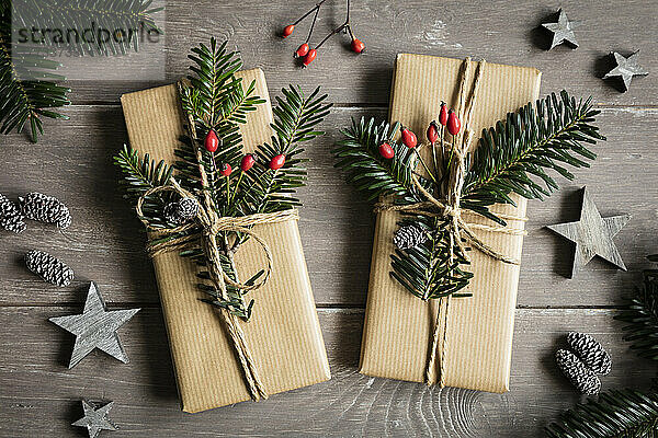 Studioaufnahme von natürlich verpackten Weihnachtsgeschenken  dekoriert mit Fichtenzweigen