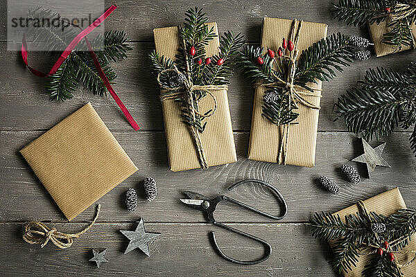 Studioaufnahme von natürlich verpackten Weihnachtsgeschenken  dekoriert mit Fichtenzweigen