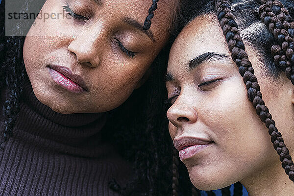 Young woman and friend with eyes closed