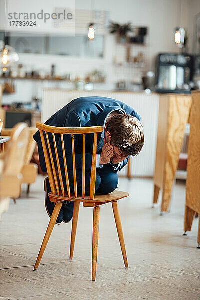 Freiberufler verspürt Angst  wenn er im Café auf einem Stuhl sitzt